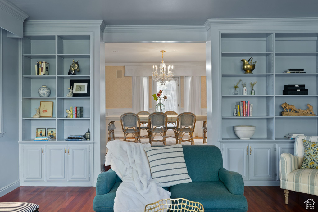 Interior space with ornamental molding, a chandelier, and dark wood-type flooring