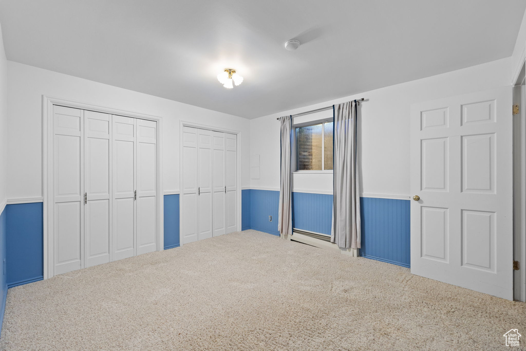 Unfurnished bedroom with carpet and multiple closets