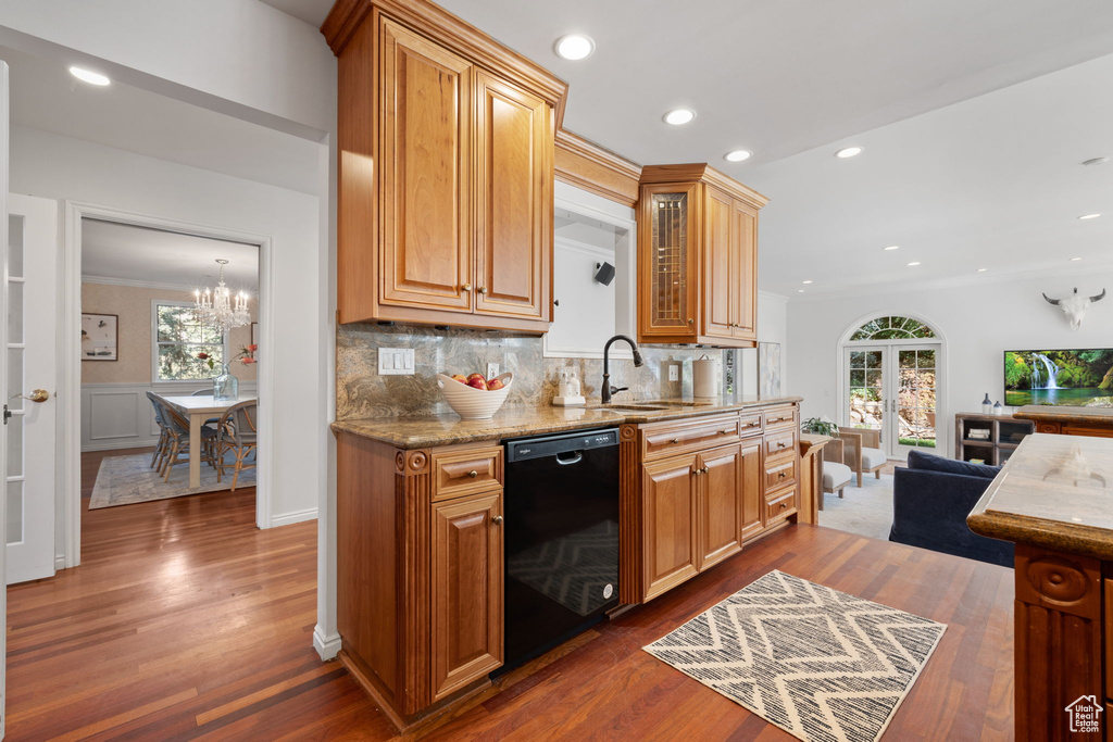 Kitchen with ornamental molding, tasteful backsplash, dishwasher, dark hardwood / wood-style floors, and an inviting chandelier