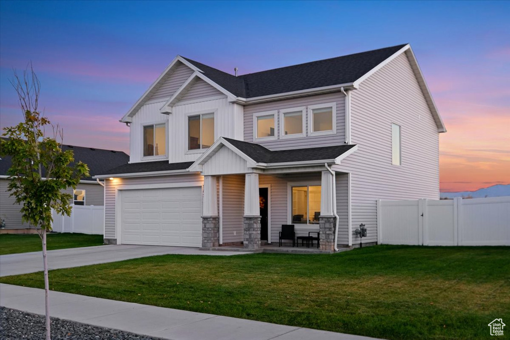 View of front facade with a lawn and a garage