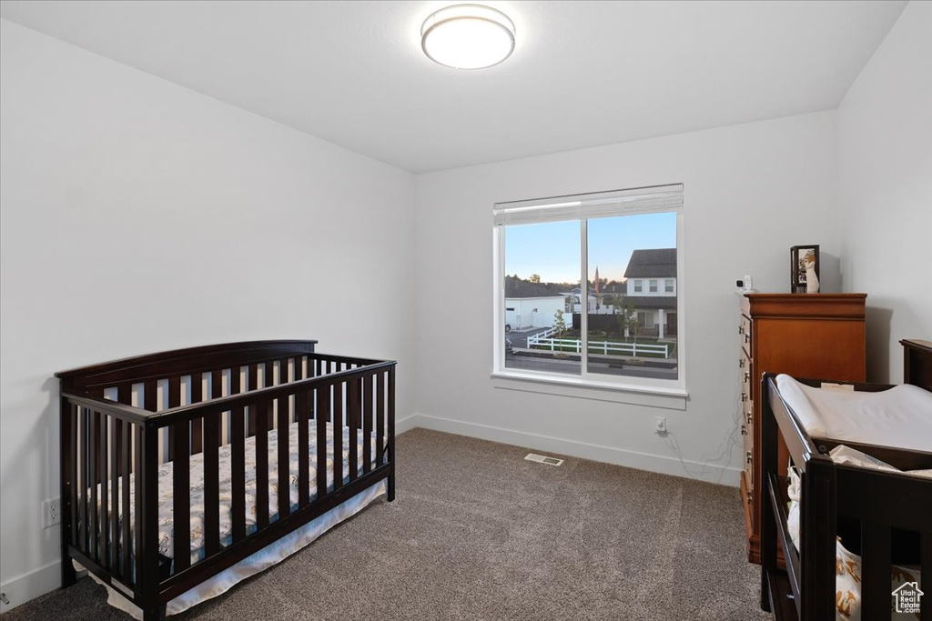 Bedroom featuring carpet and a nursery area