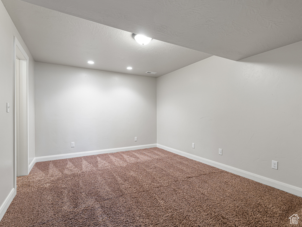 Carpeted empty room with baseboards, recessed lighting, and a textured ceiling