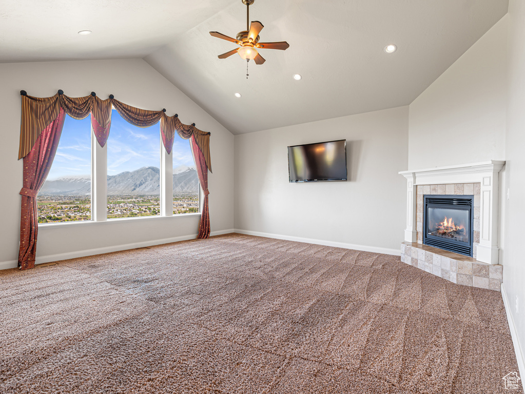 Unfurnished living room with recessed lighting, vaulted ceiling, ceiling fan, a fireplace, and carpet flooring