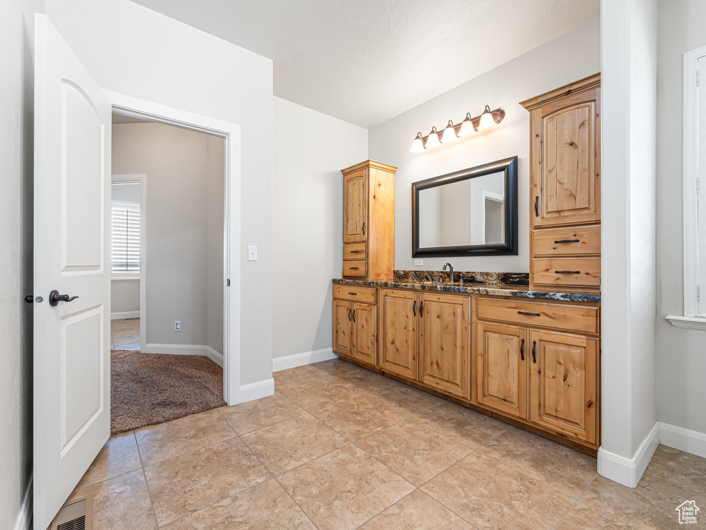 Bathroom featuring tile patterned floors, visible vents, baseboards, and vanity