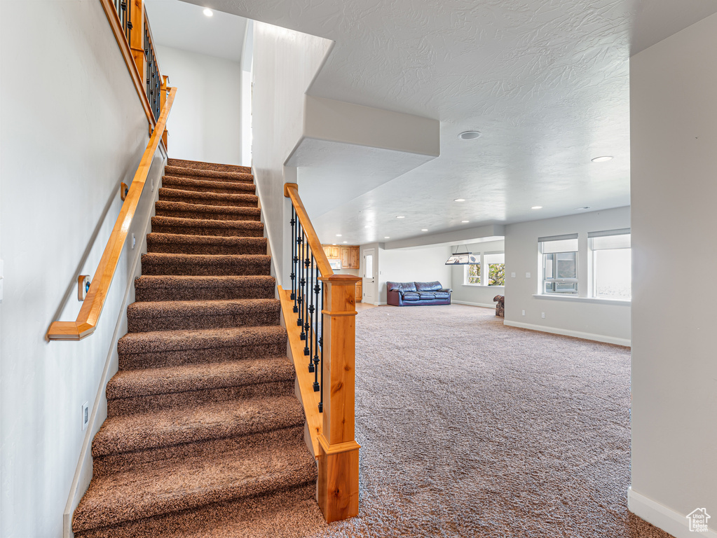 Staircase featuring baseboards, carpet flooring, and recessed lighting