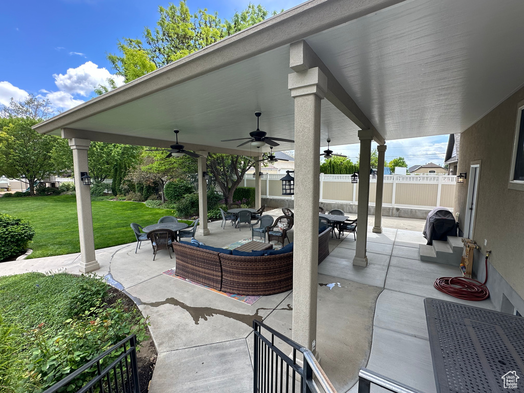 View of patio with outdoor dining area and ceiling fan