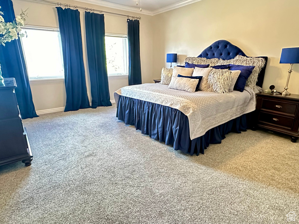 Carpeted bedroom with ornamental molding and baseboards