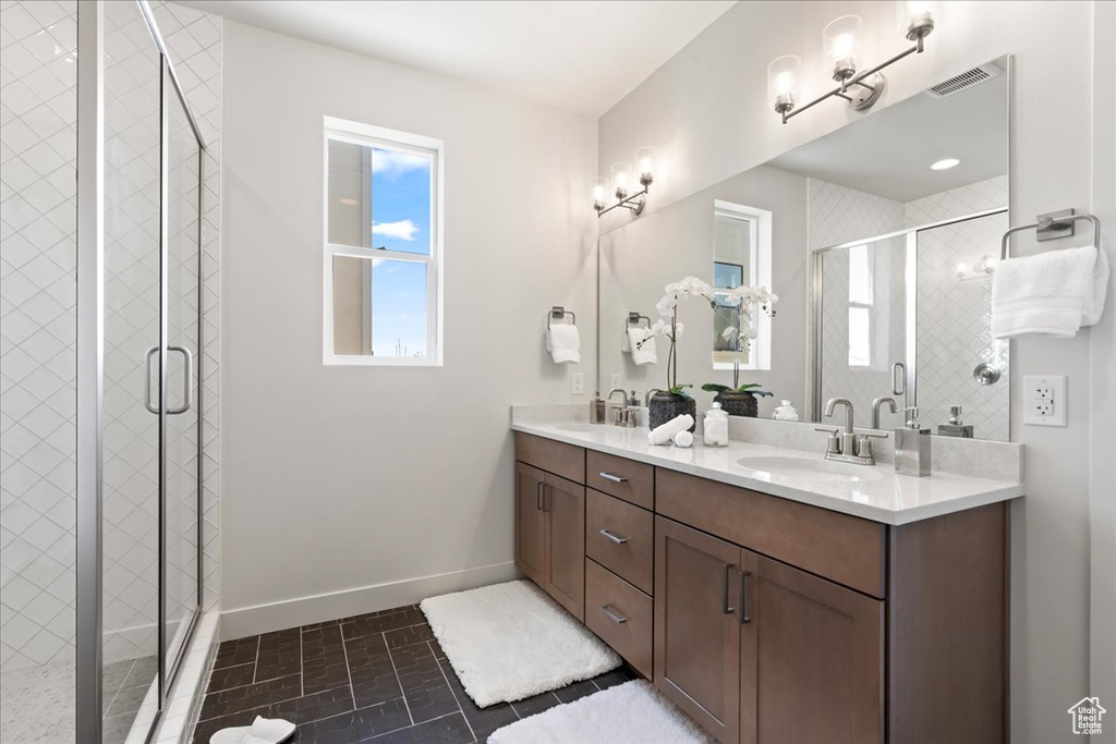 Bathroom with tile patterned flooring, a shower with shower door, and vanity