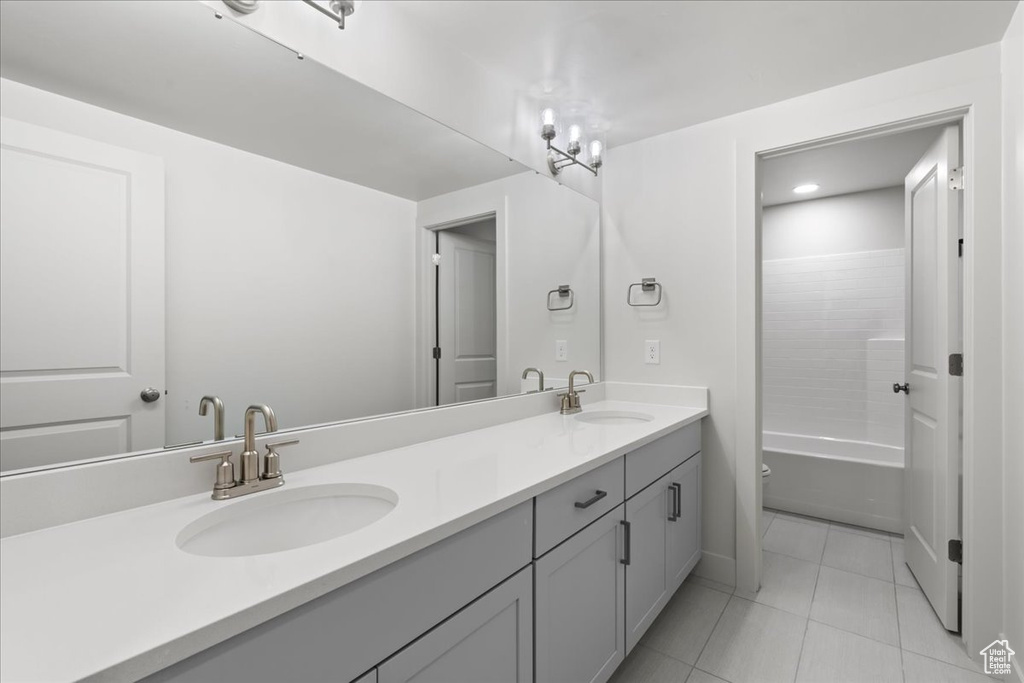 Bathroom with washtub / shower combination, vanity, a chandelier, and tile patterned floors