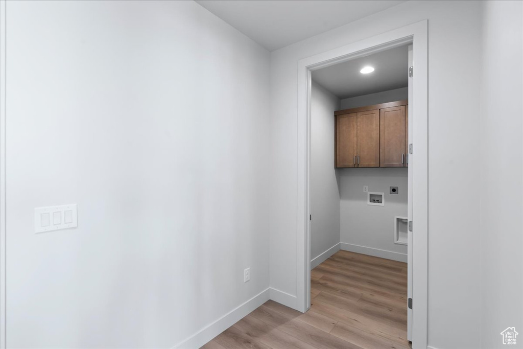 Laundry room featuring cabinets, light wood-type flooring, electric dryer hookup, and washer hookup