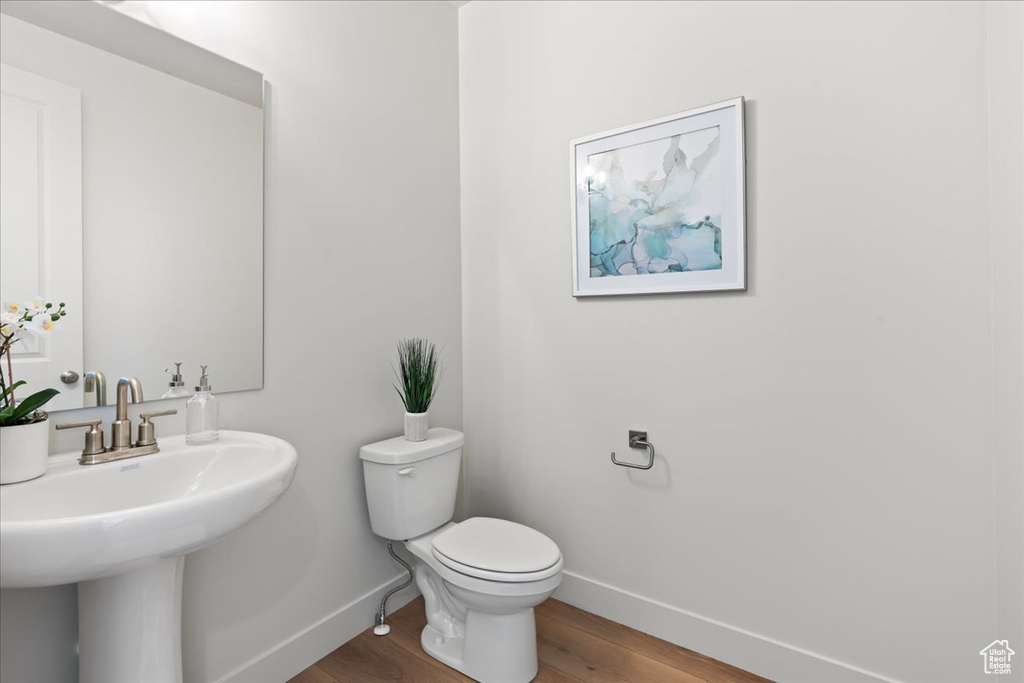 Bathroom featuring wood-type flooring, sink, and toilet