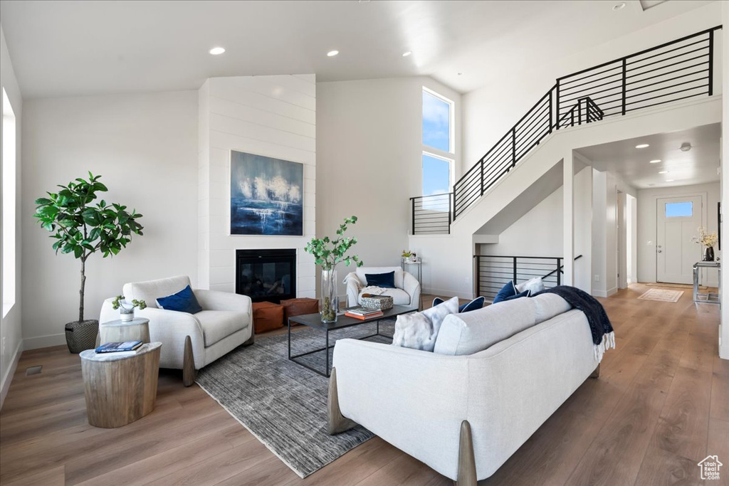 Living room featuring hardwood / wood-style flooring, a fireplace, and high vaulted ceiling