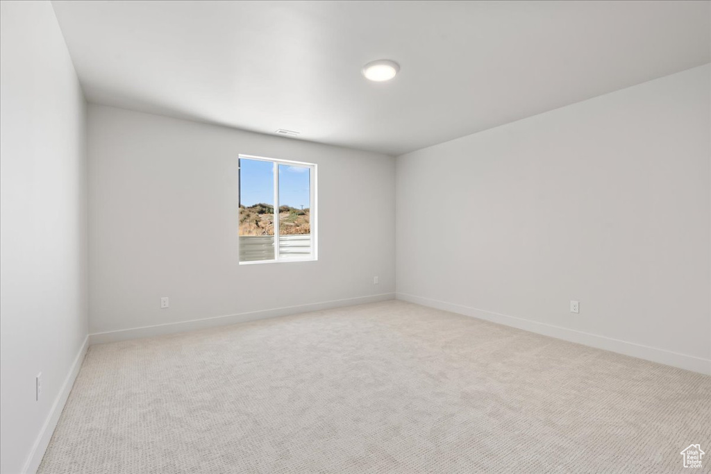 Unfurnished room featuring light carpet