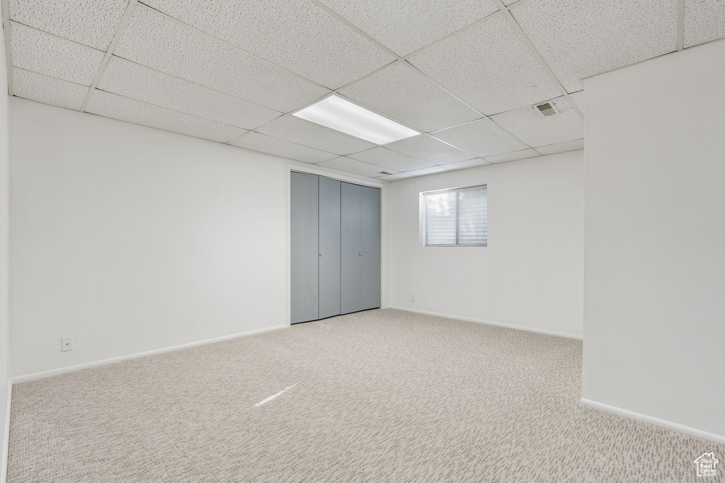 Unfurnished room with light carpet and a paneled ceiling