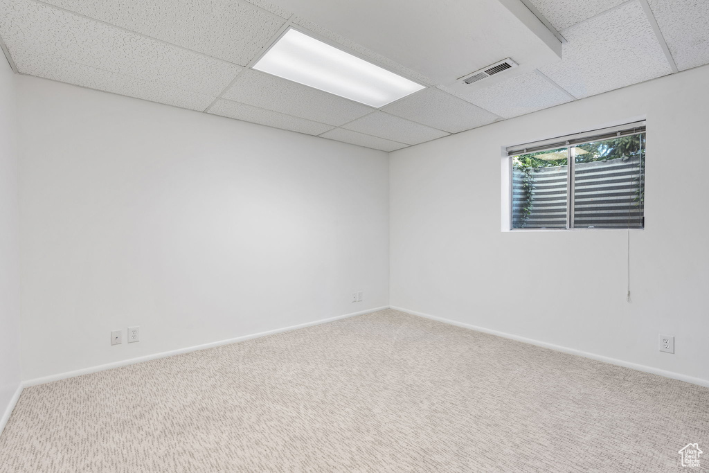 Unfurnished room featuring carpet flooring and a paneled ceiling