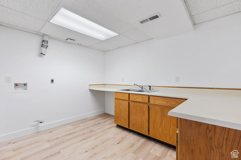 Kitchen featuring a drop ceiling, light wood-type flooring, and sink