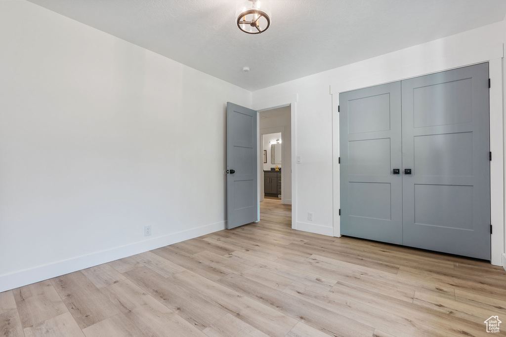 Unfurnished bedroom with light wood-type flooring and a closet