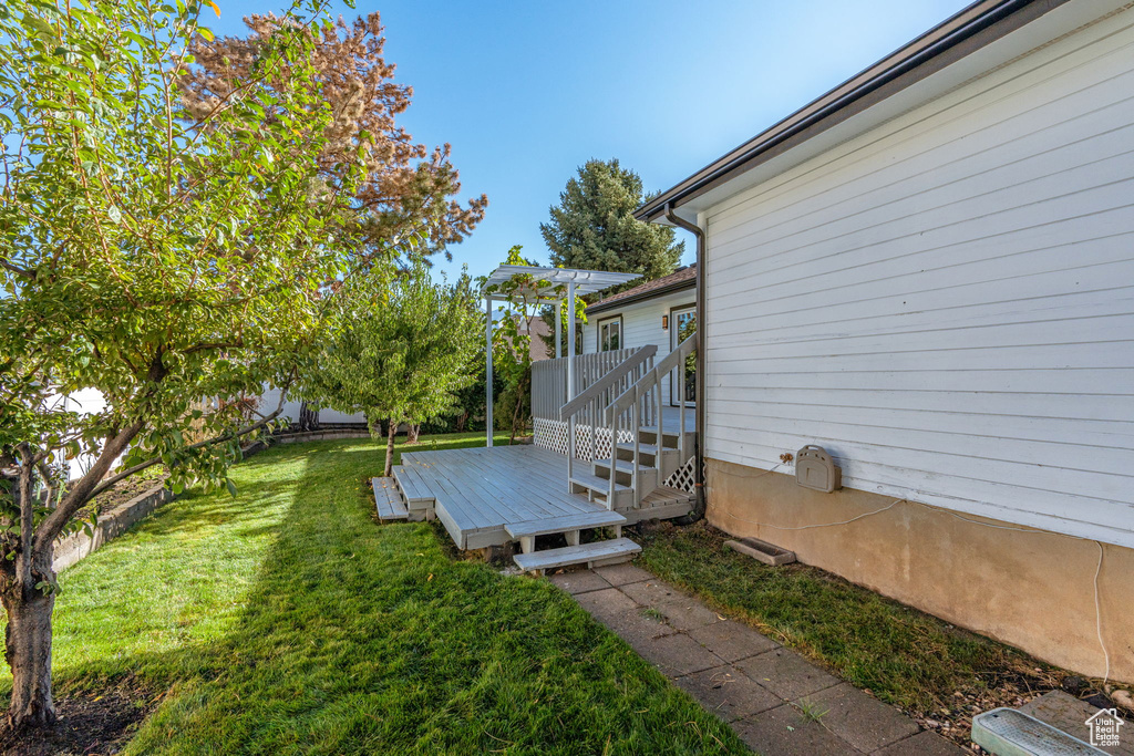 View of yard featuring a wooden deck and a pergola