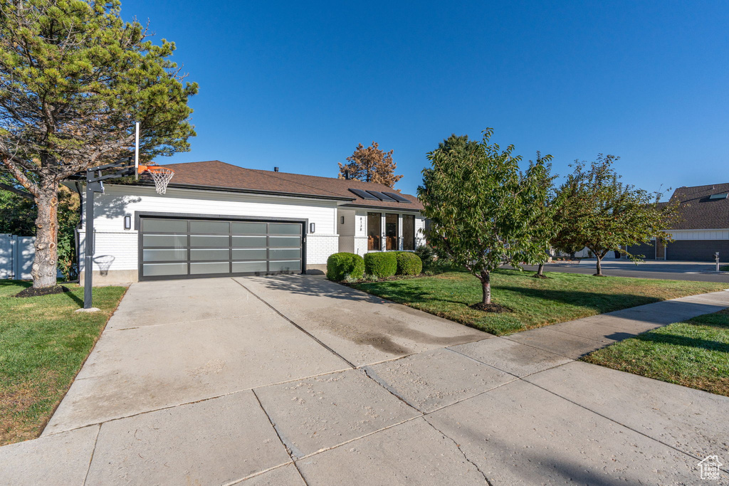 Ranch-style house with a garage and a front yard