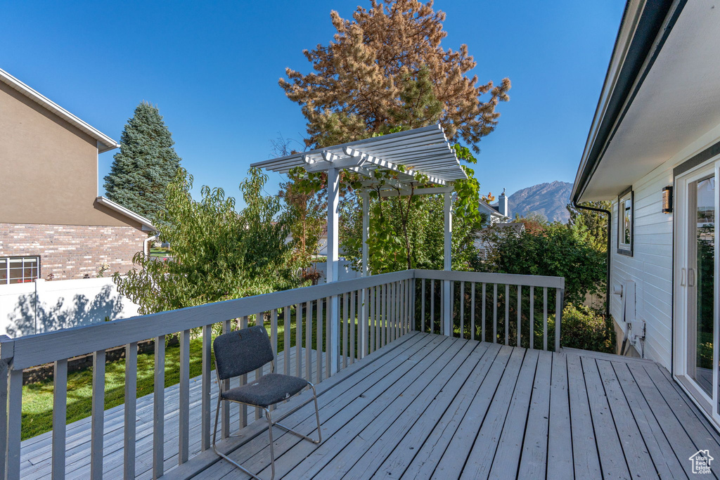 Wooden deck with a mountain view and a pergola