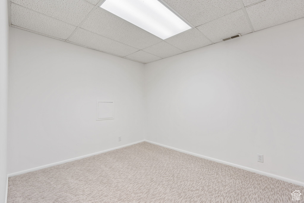 Spare room featuring a paneled ceiling and carpet flooring