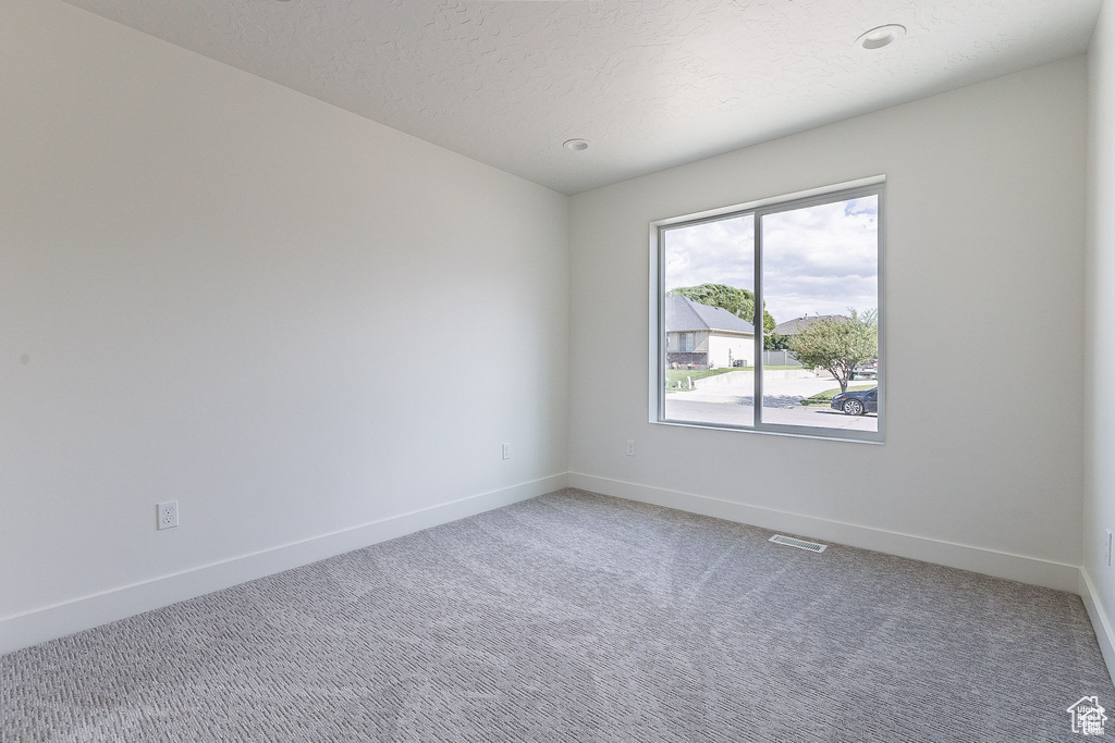 Unfurnished room featuring carpet floors and a textured ceiling