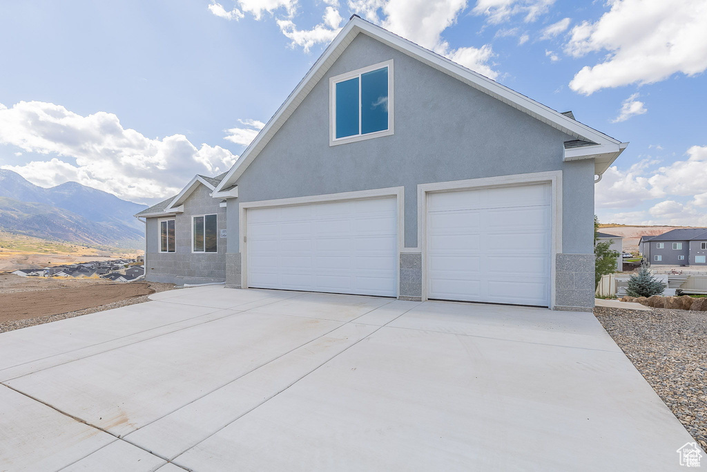 View of front facade featuring a garage and a mountain view