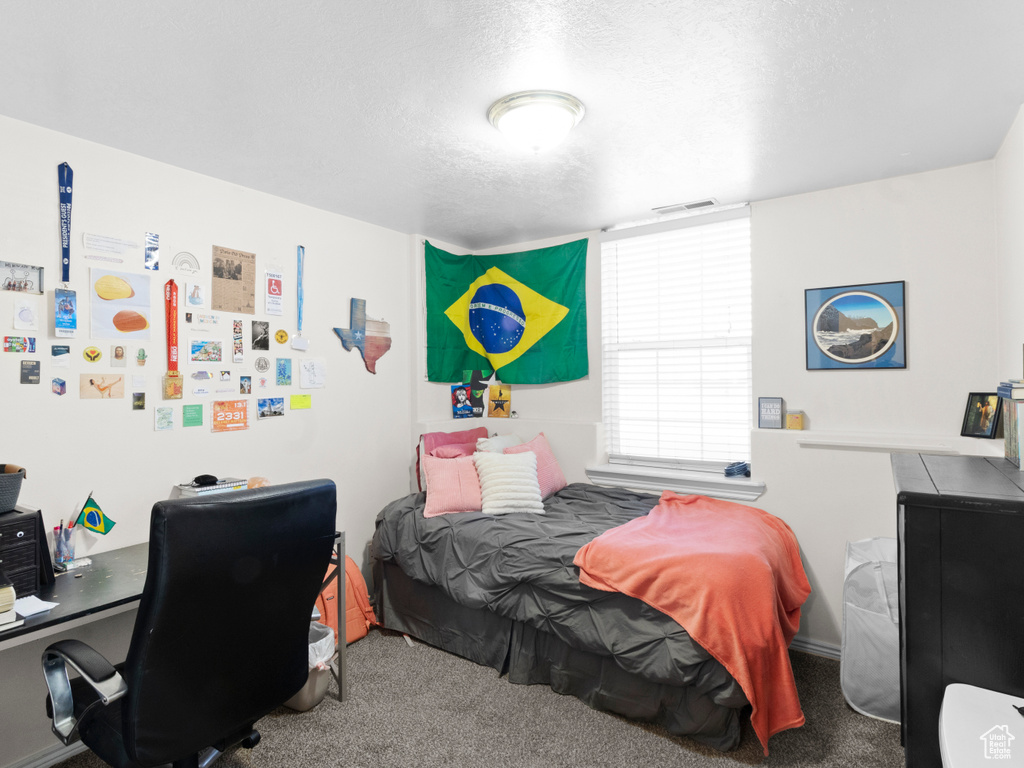 Bedroom with a textured ceiling and carpet