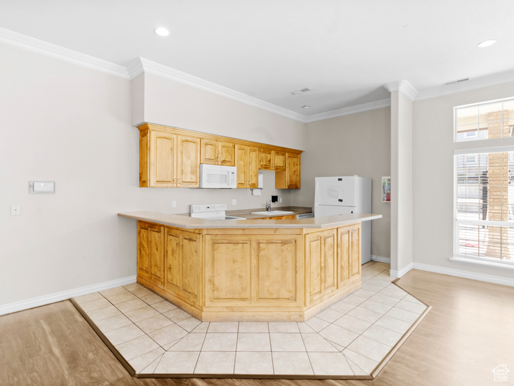 Kitchen featuring ornamental molding, sink, kitchen peninsula, white appliances, and light wood-type flooring