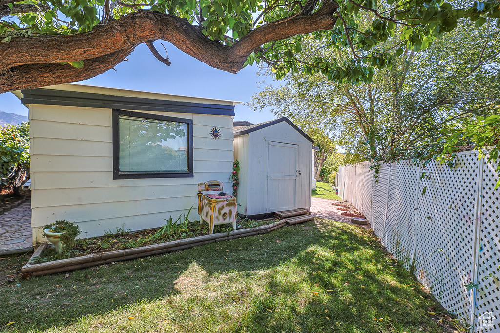 Exterior space featuring a lawn and a storage unit