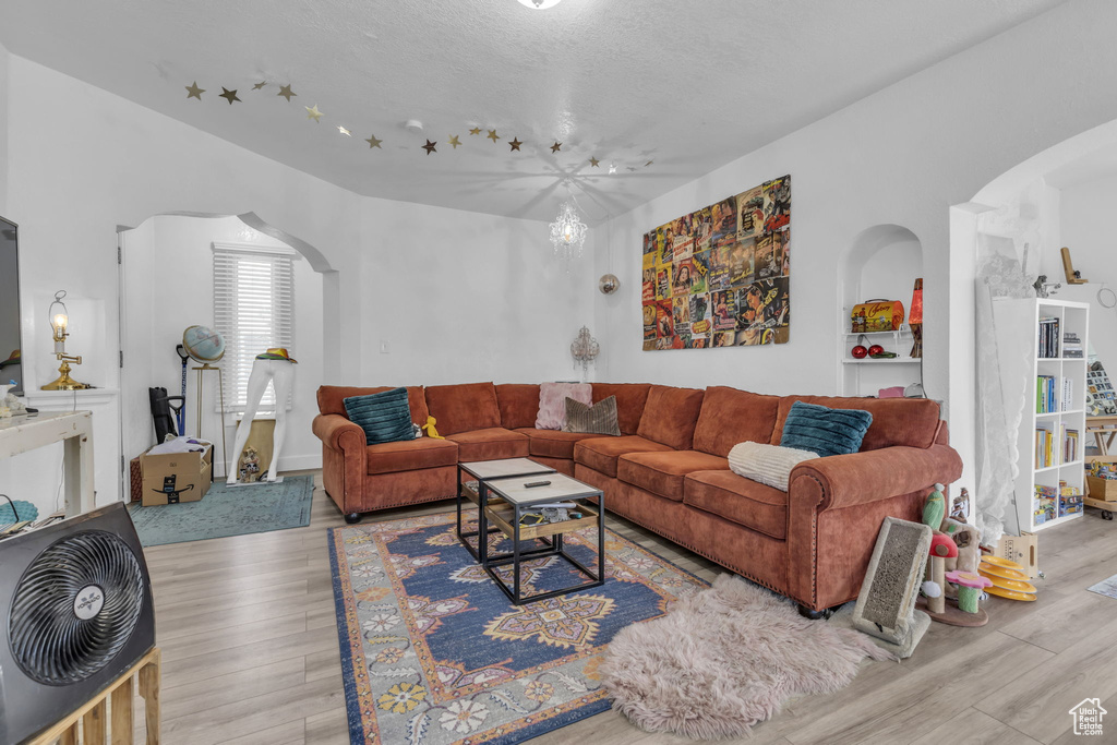 Living room featuring a textured ceiling and light hardwood / wood-style flooring