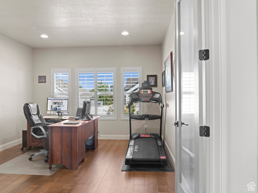 Office area with a textured ceiling and light wood-type flooring