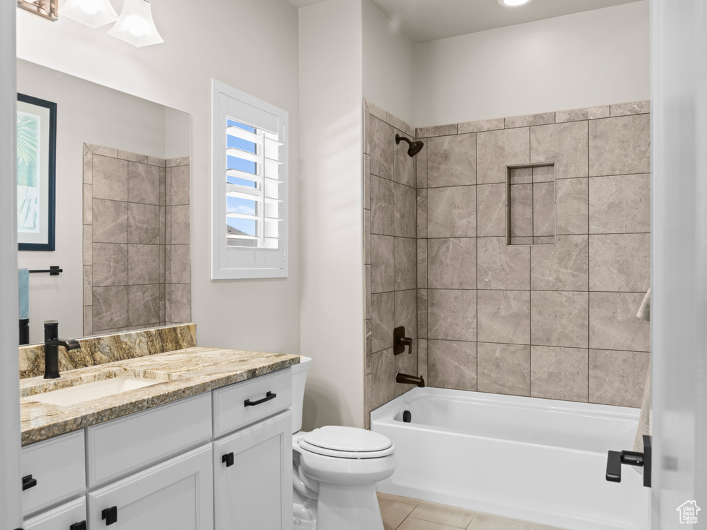 Full bathroom with vanity, tiled shower / bath combo, toilet, and tile patterned floors