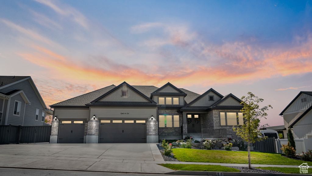 View of front of house with a garage and a yard