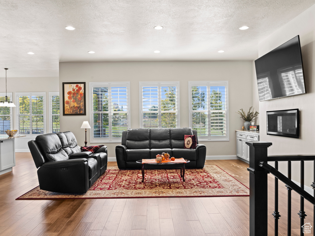 Living room featuring a textured ceiling and light hardwood / wood-style flooring