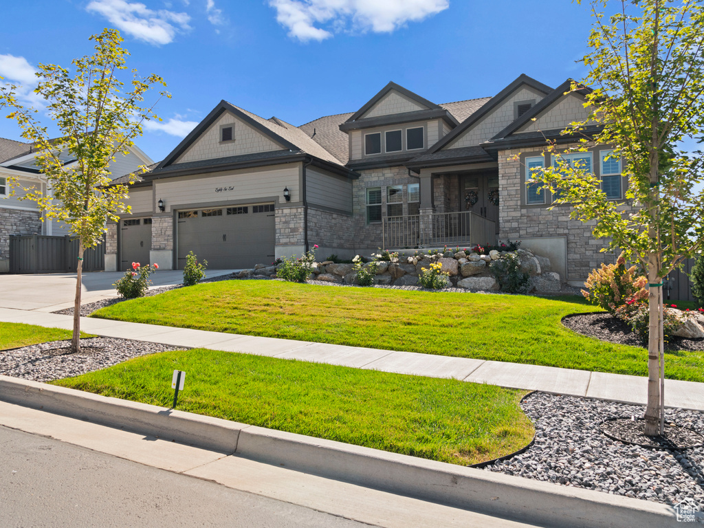 Craftsman-style house with a garage and a front yard