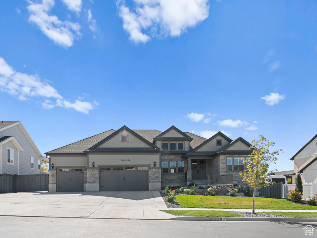 View of front of home featuring a front lawn and a garage