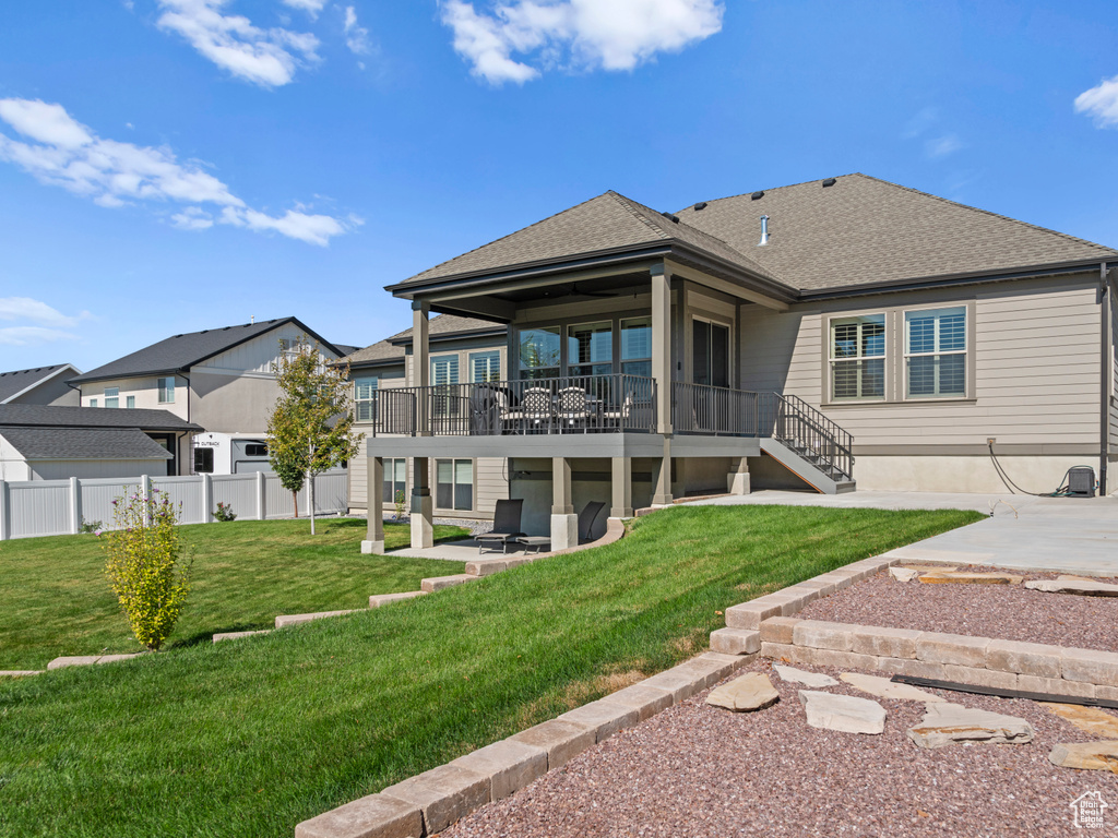 Back of house featuring a lawn and a patio