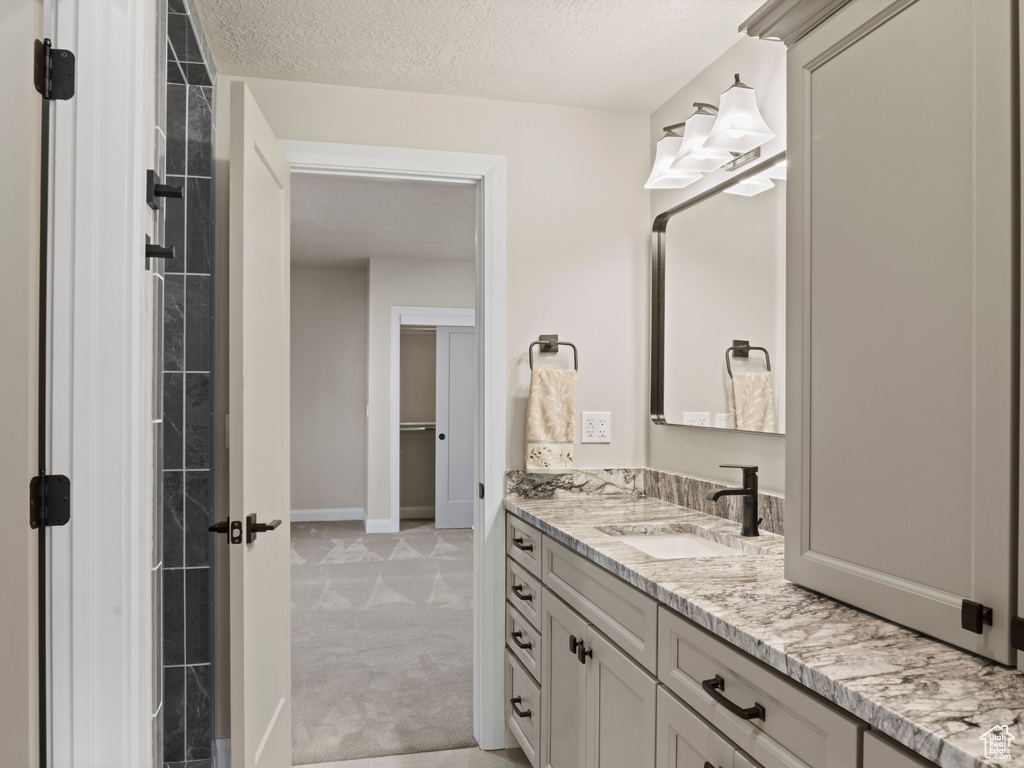 Bathroom featuring a textured ceiling and vanity