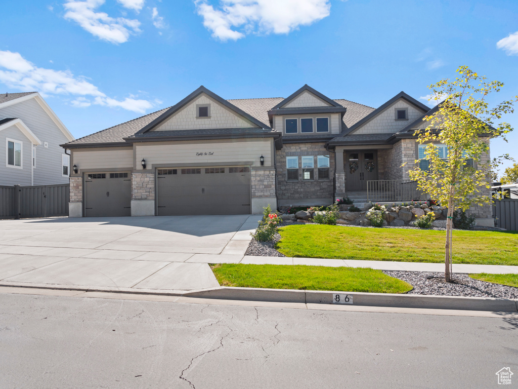 Craftsman-style house featuring a front yard and a garage