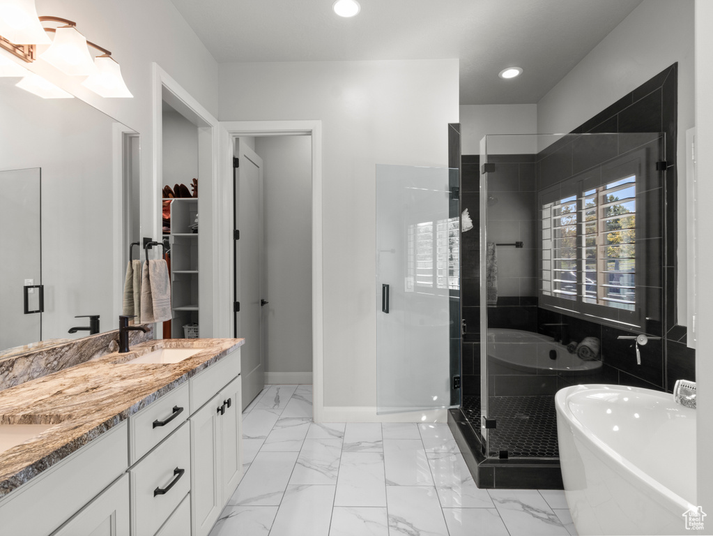 Bathroom featuring vanity and separate shower and tub