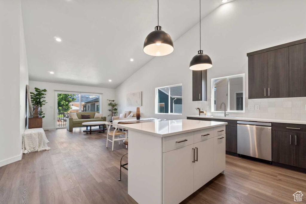 Kitchen with a kitchen island, dark brown cabinetry, white cabinetry, and dishwasher