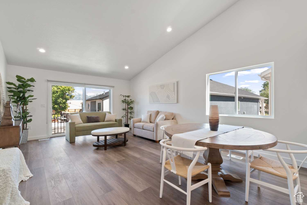 Dining area featuring high vaulted ceiling and hardwood / wood-style flooring