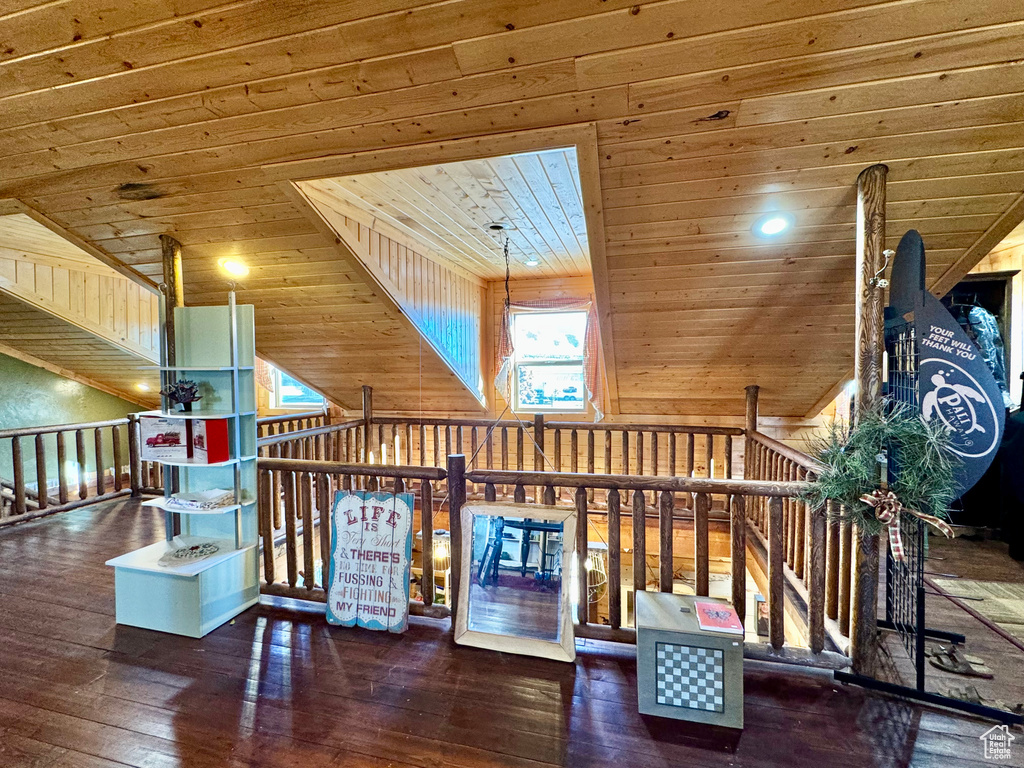 Interior space with wooden walls, dark hardwood / wood-style flooring, and wood ceiling