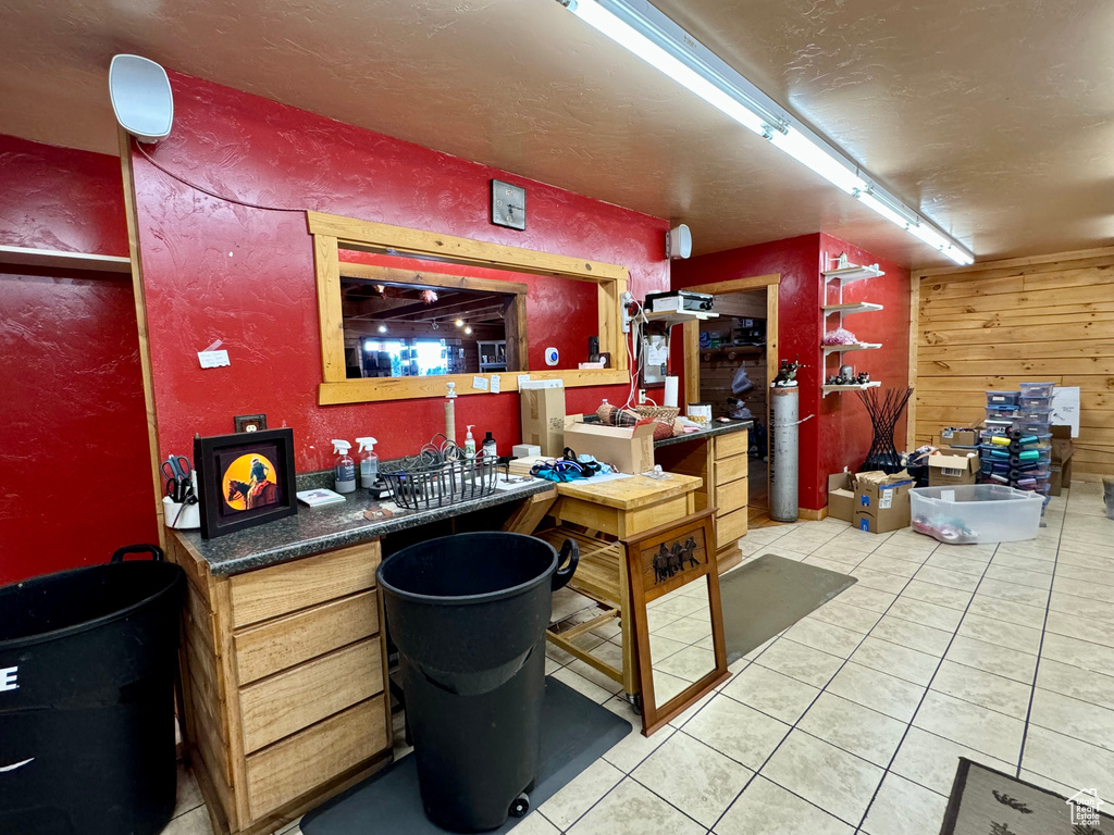 Bar featuring tile patterned flooring and wood walls