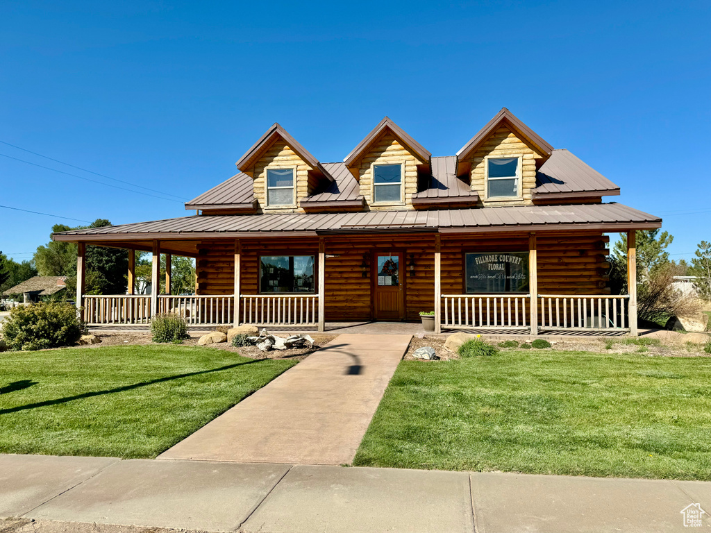 Cabin featuring a front lawn and a porch