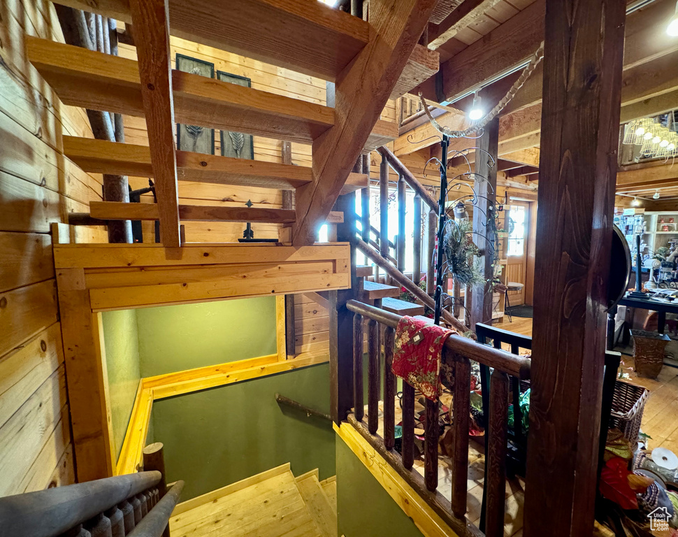 Stairway featuring wood walls and hardwood / wood-style flooring