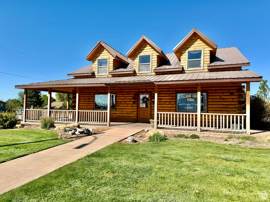 Cabin with a porch and a front lawn