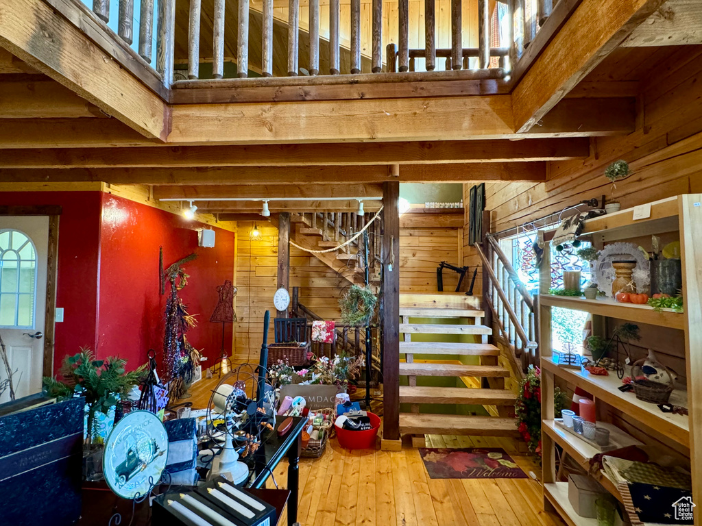 Basement with wood-type flooring, wooden walls, and rail lighting