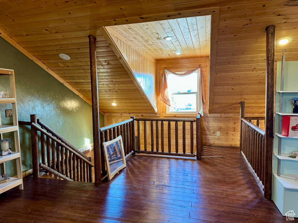 Interior space featuring vaulted ceiling, wood ceiling, wood walls, and dark wood-type flooring